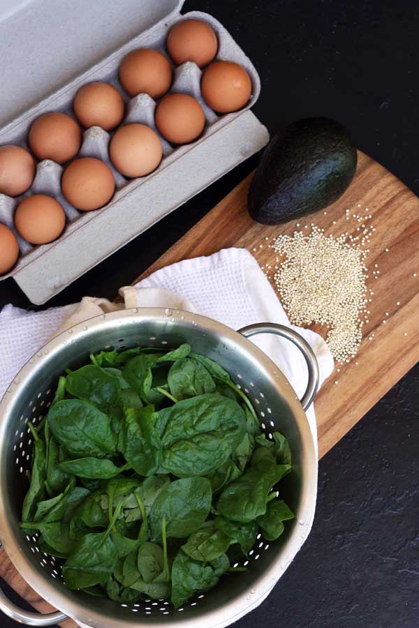 Ingredients for a breakfast of poached eggs with avocado, spinach & crispy quinoa