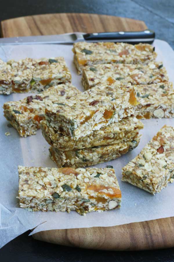 A stack of no bake granola bars on baking paper