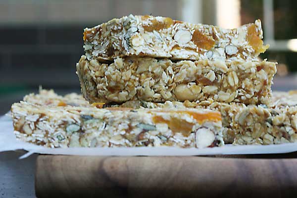 Close up of a small stack of no bake granola bars on a wooden board