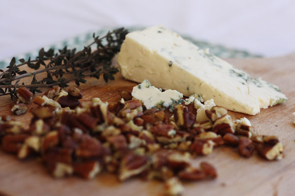 A close up of blue cheese and walnuts for making sausage tray bake with sweet potatoes and orange.