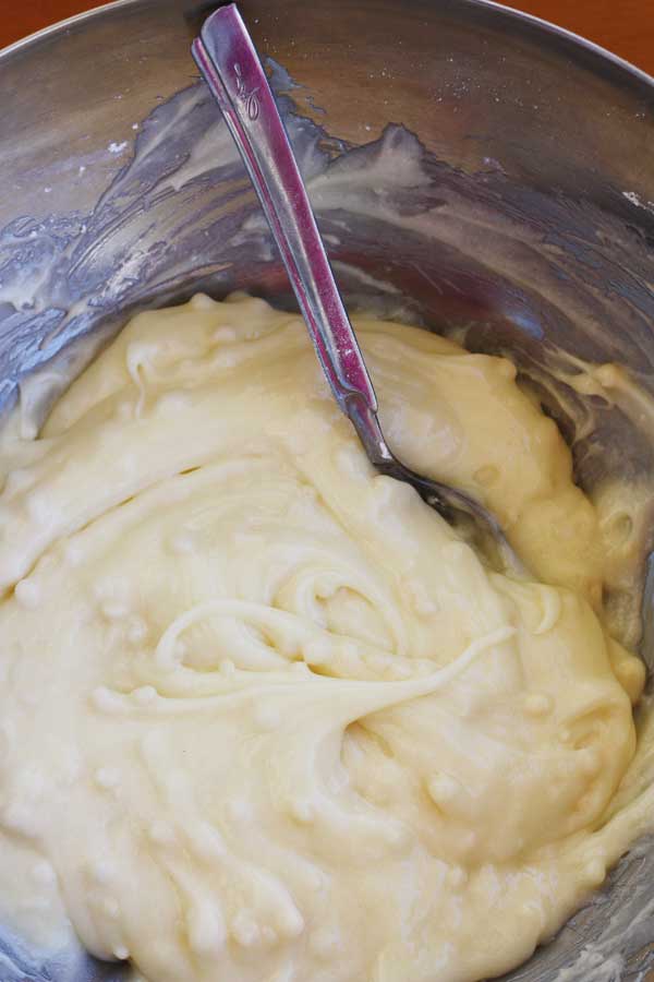 closeup of the white chocolate cream cheese frosting for a banana pistachio loaf
