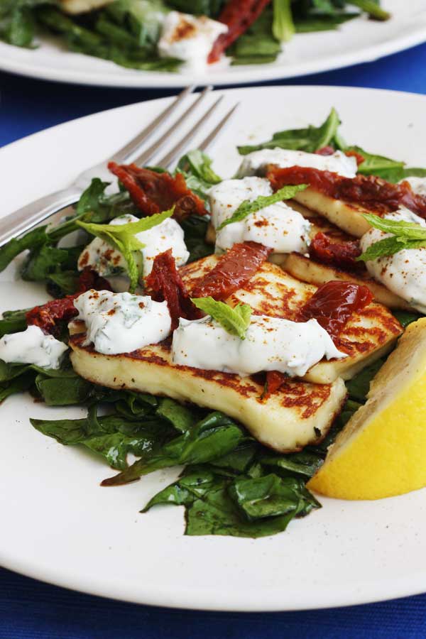 A closeup of a halloumi salad with a fork next to it 