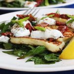 A plate of halloumi salad with another in the background