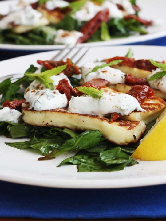 A plate of halloumi salad with another in the background