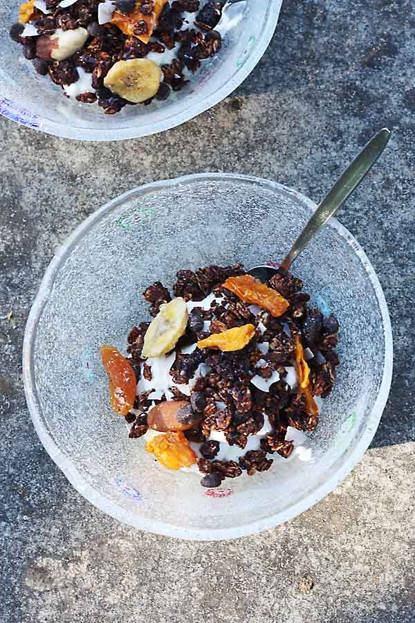 Tropical chocolate granola in a bowl from above with a spoon in it