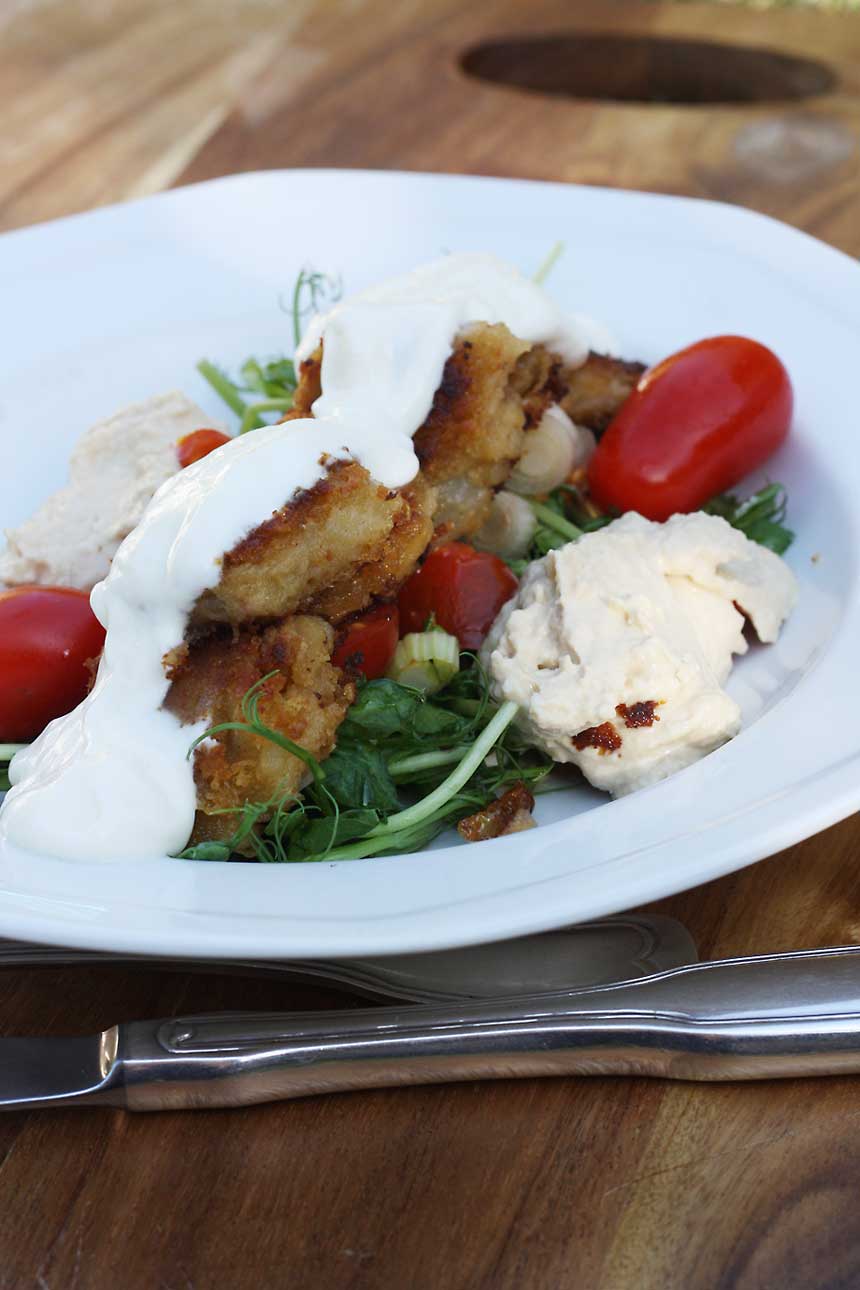 A plate of fsweet potato falafel in a white bowl with salad.