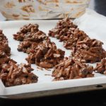 Chocolate rocks on a baking tray with a big bowl in the background