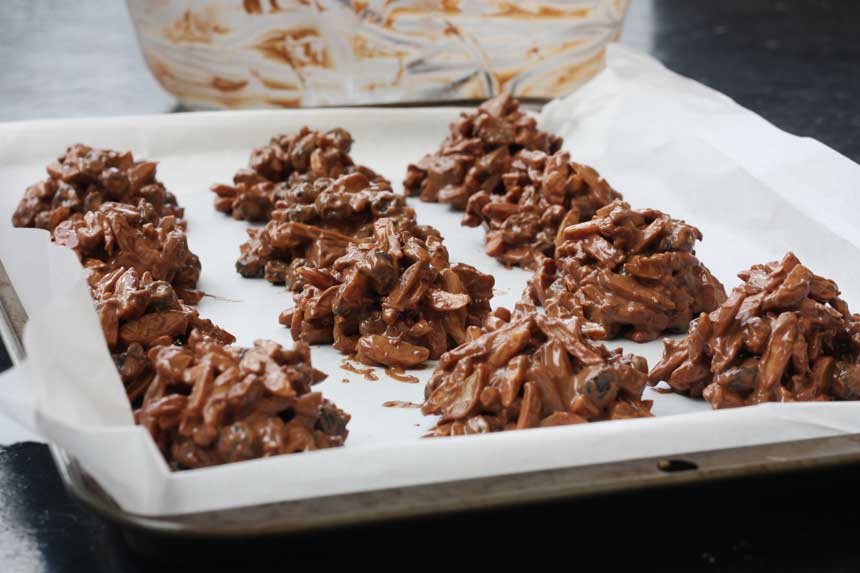 Chocolate rocks on a baking tray with a big bowl in the background