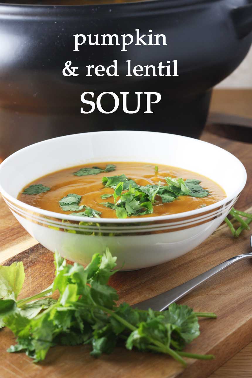 Crock pot Thai pumpkin and red lentil soup on a wooden board and with a spoon with a title on it for Pinterest