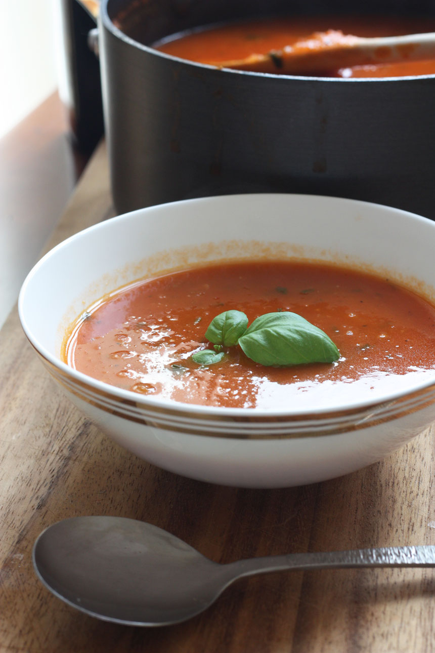A classic tomato soup in a white bowl on a cutting board