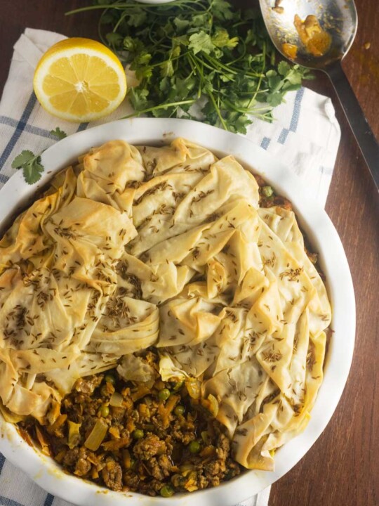 an overhead photo of a samosa pie with a scrunched filo pastry top