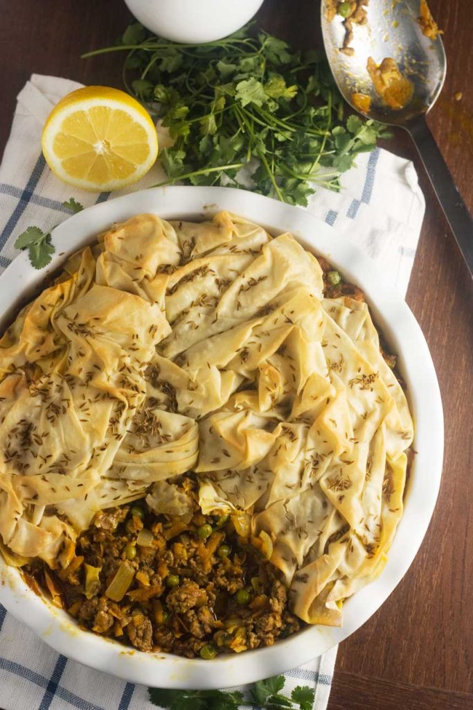 an overhead photo of a samosa pie with a scrunched filo pastry top