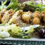 A close up of a plate of chicken katsu curry on a checked green cloth