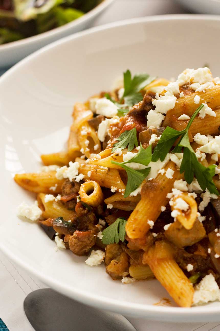 A closeup of a bowl of penne pasta with eggplant.