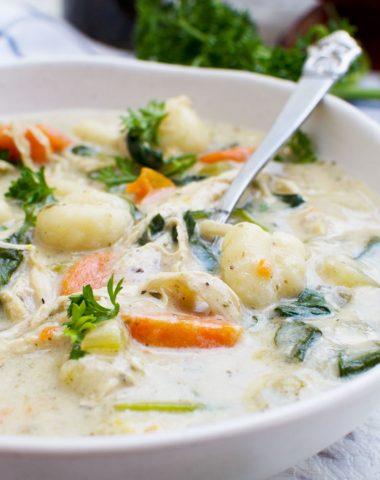 A close up of crockpot chicken gnocchi soup in a white bowl