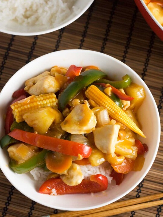 An overhead shot of a dish of quick sweet and sour chicken on a brown place mat