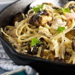 A closeup of a black frying pan with turkey linguine in it.