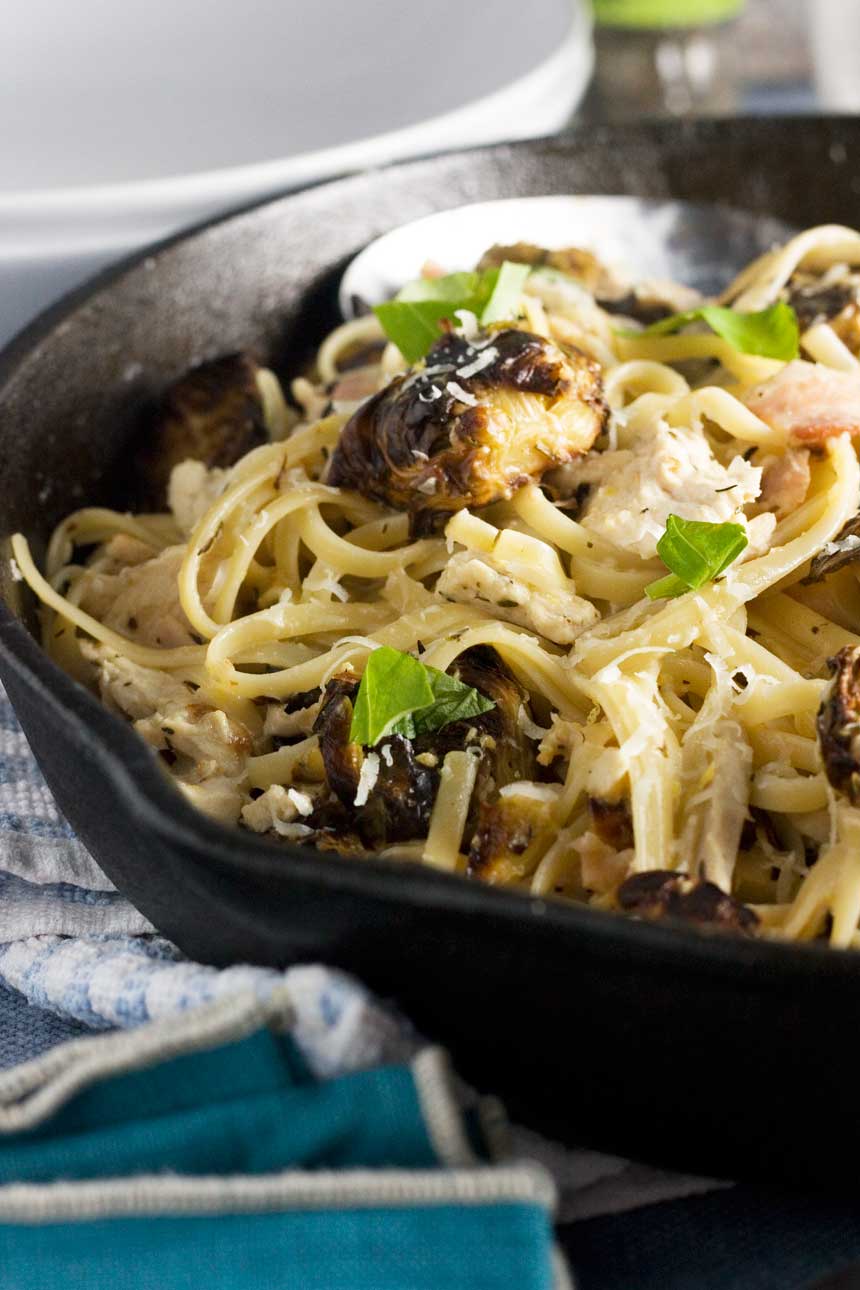 A closeup of a black frying pan with turkey linguine in it.