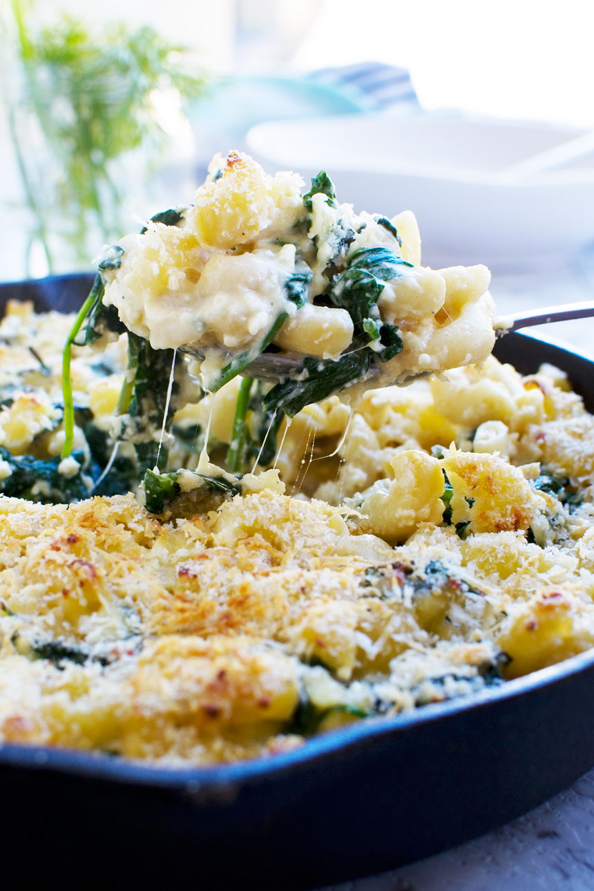 a really easy Greek mac and cheese bake being served with a big spoon