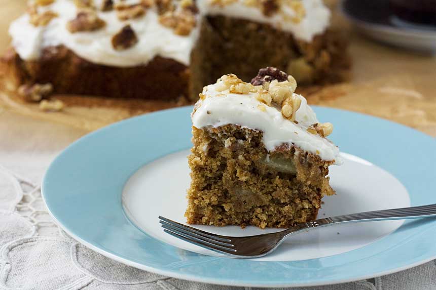 A piece of Hummingbird cake on a light blue plate with a fork