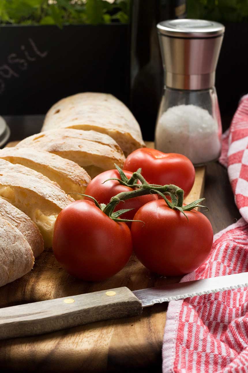 A close up of ingredients for pan con tomate on a wooden table