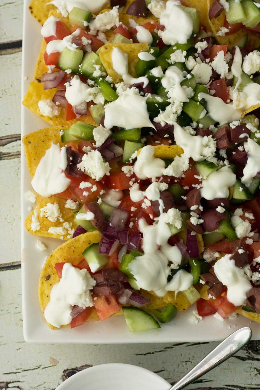 Part of a plate of Greek nachos photographed from above.