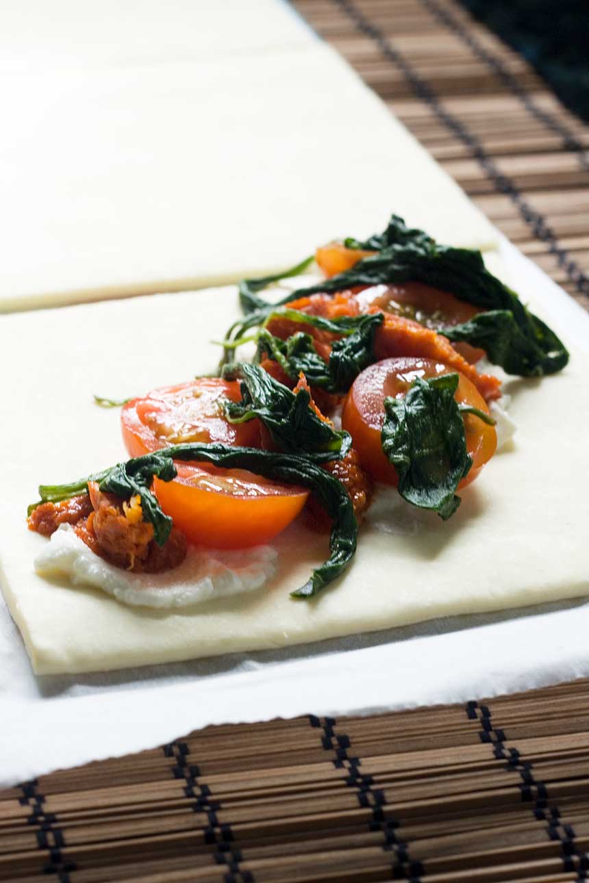 closeup of the stuffing for Ricotta, cherry tomato and chorizo puff pastry tarts on a square of pastry.