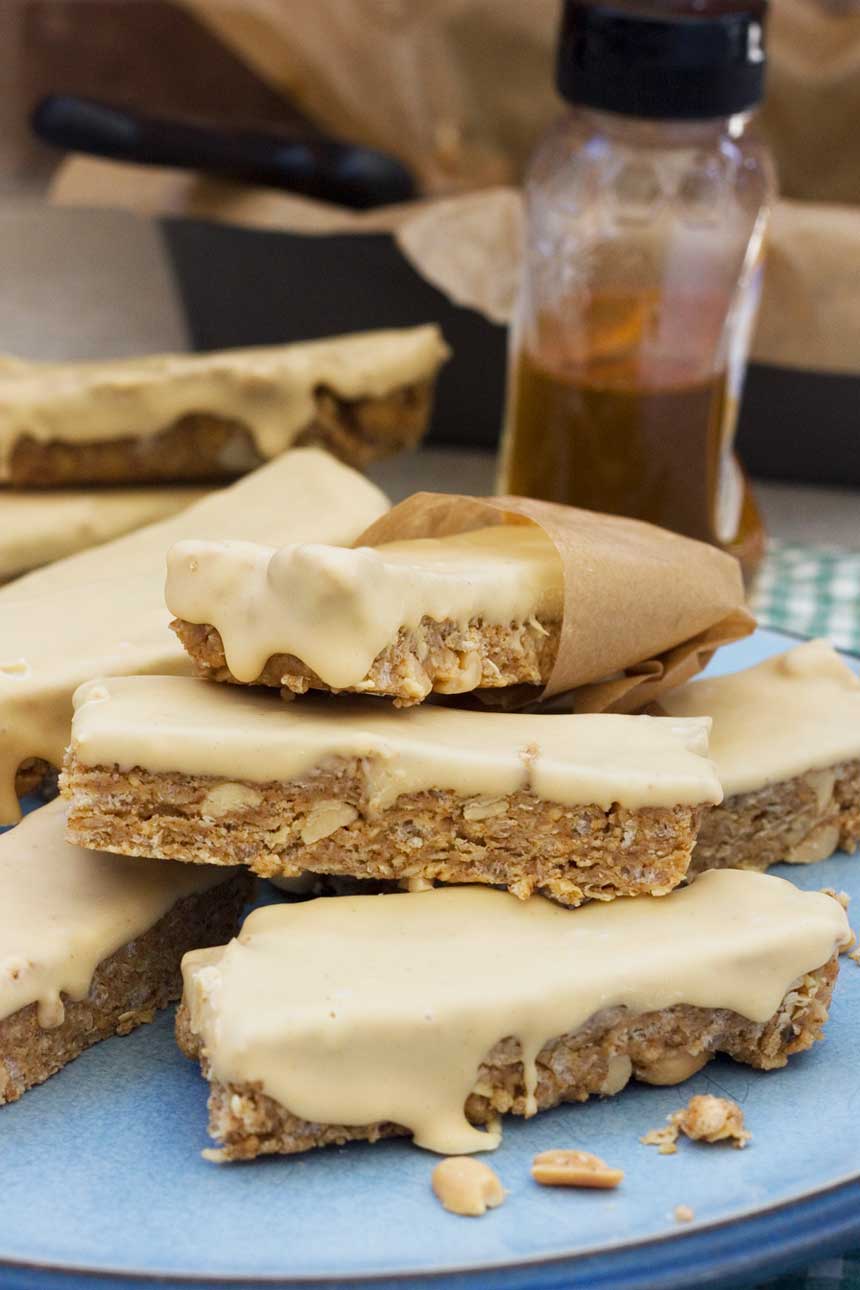 A stack of homemade sweet and salty peanut granola bars with ingredients in the background