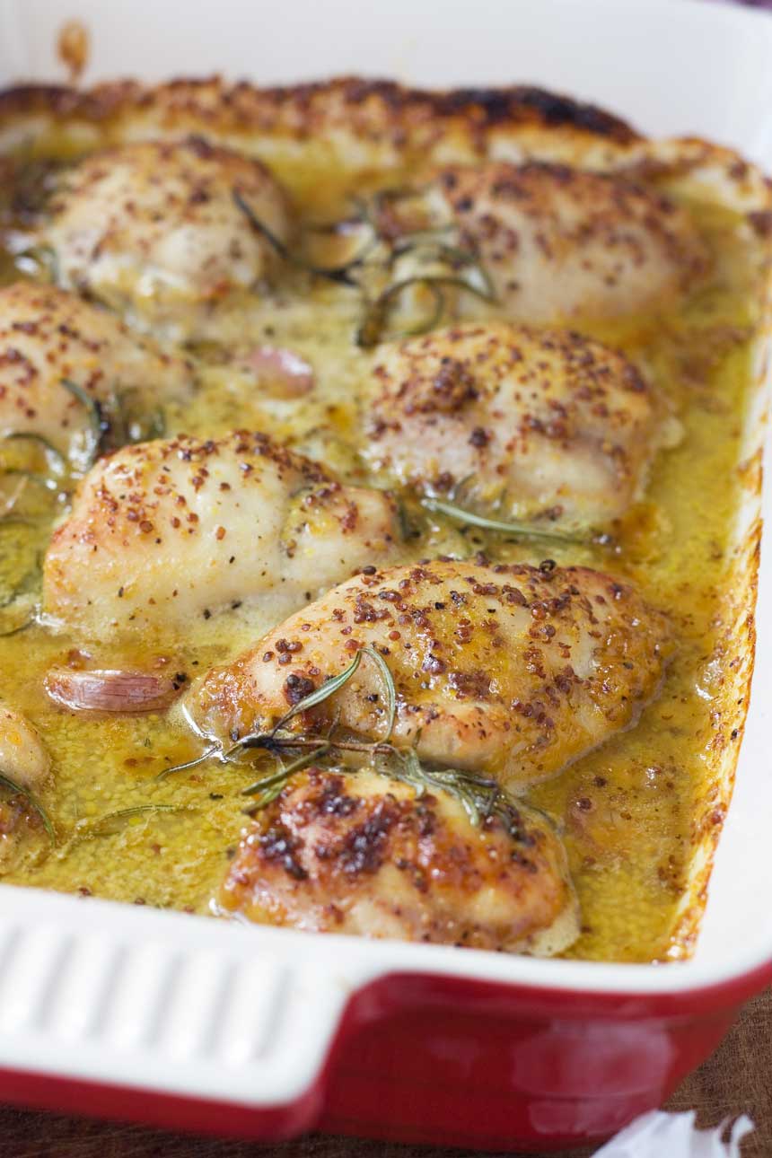 A closeup of baked honey mustard chicken in a baking dish from above.