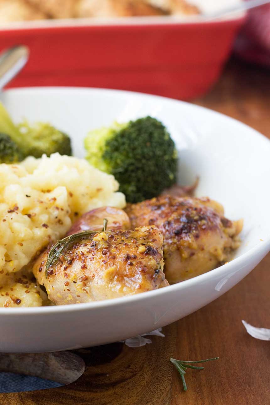 A closeup of \'No recipe\' baked honey mustard chicken with mashed potatoes and broccoli in a white bowl.