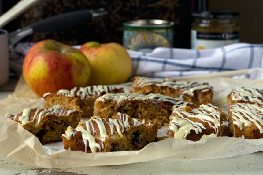 sticky apple ginger cake bars on baking paper with ingredients in the background