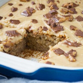 closeup of a blue baking dish of banana slice with peanut butter icing with a big slice taken out.