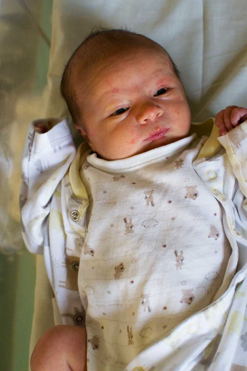 A baby lying in a bassinet.