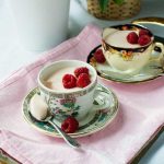 Greek yogurt panna cotta in pretty tea cups on a pink cloth.