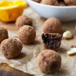 closeup of healthy chocolate orange truffles on baking paper with ingredients in the background