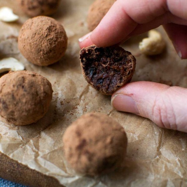 5-ingredient healthy chocolate orange truffles in a white bowl on baking paper with more truffles scattered around