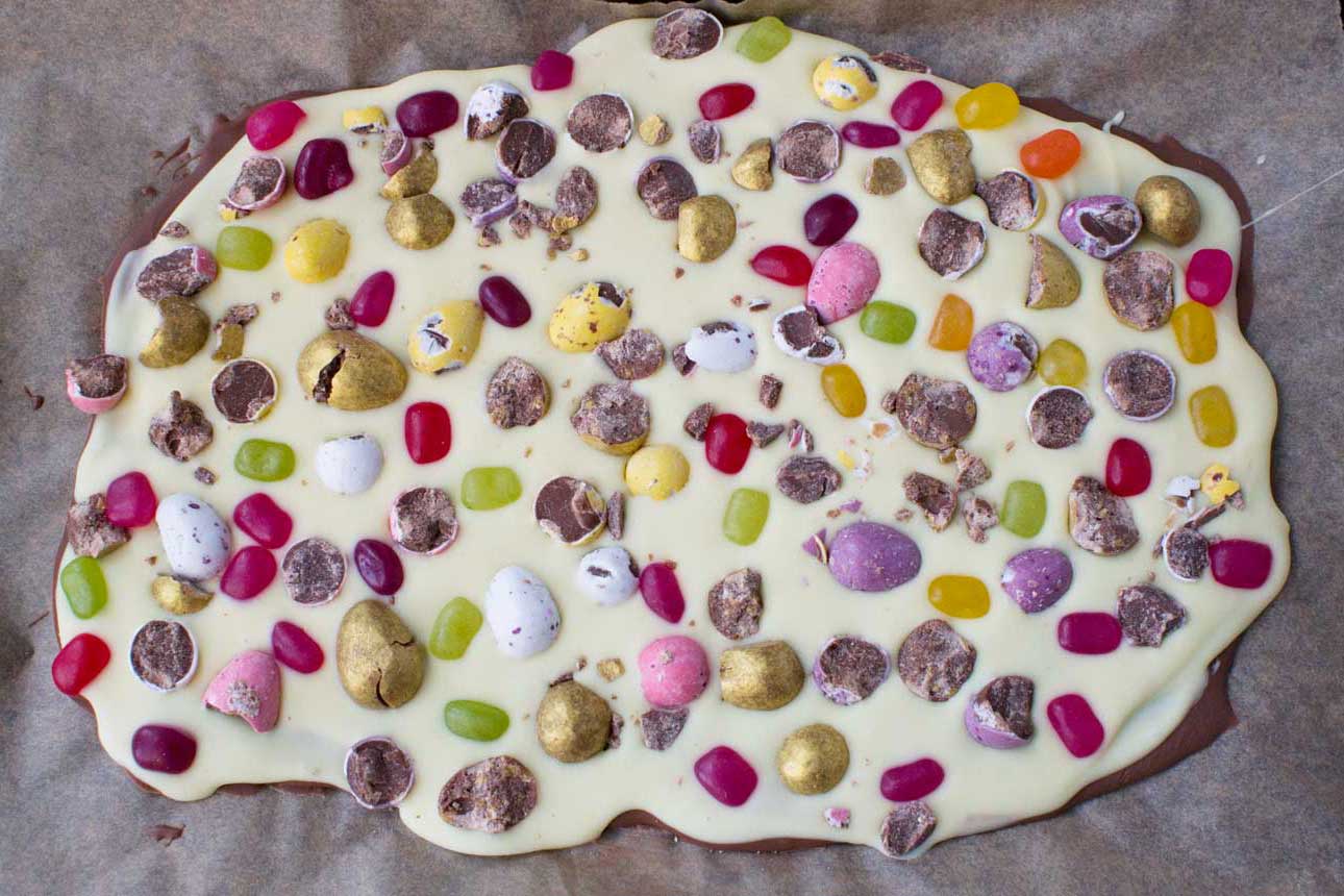 Easter chocolate bark before being broken into pieces on baking paper from above.