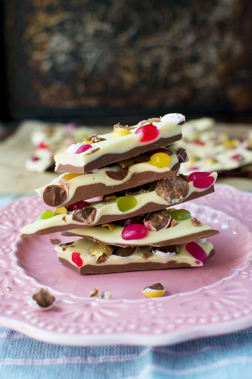 A stack of Easter chocolate bark on a pink plate.