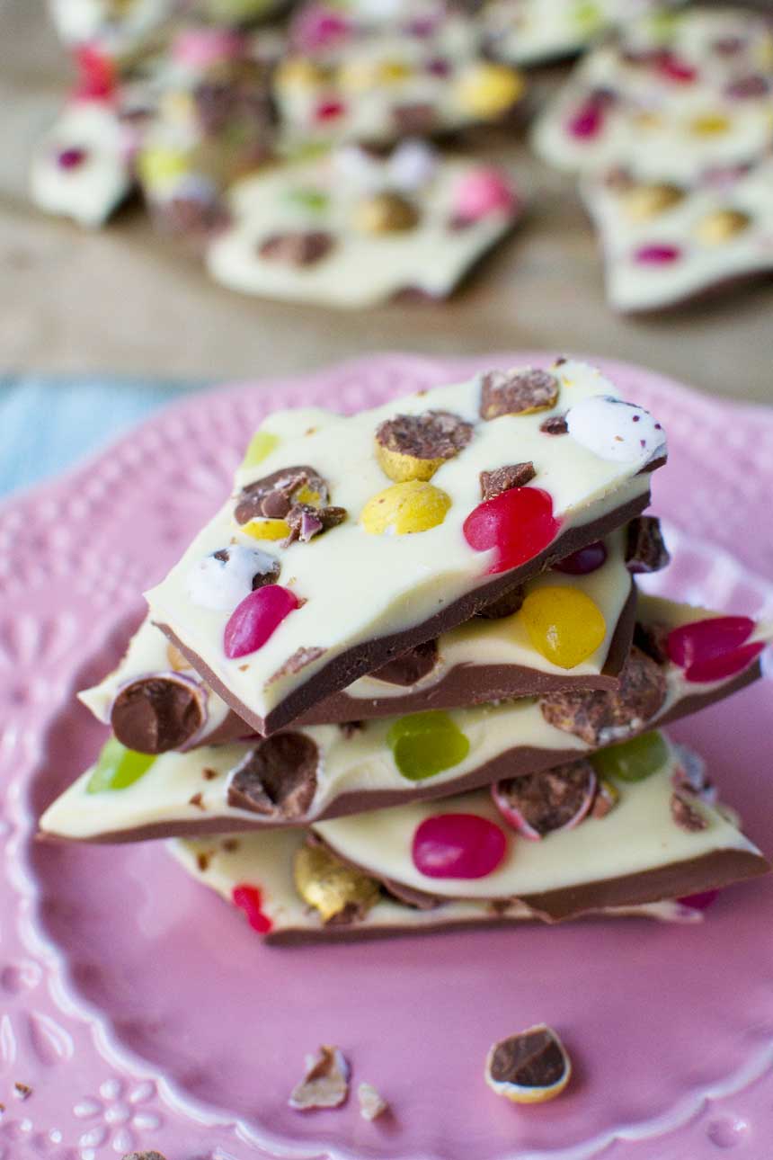 Closeup of a stack of Easter chocolate bark on a pink plate.