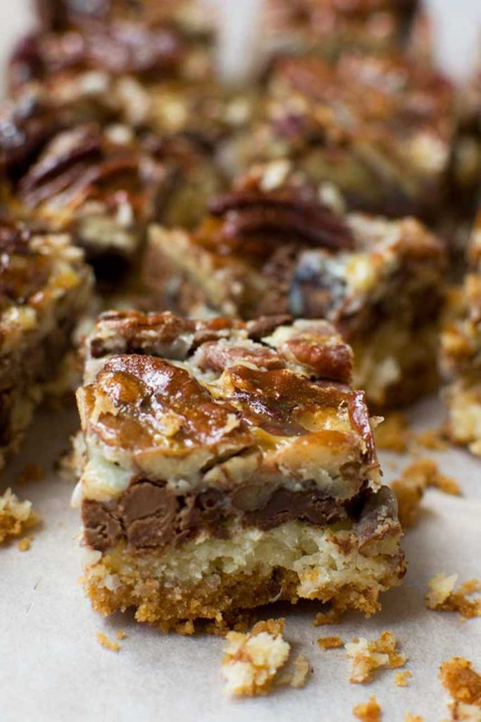 A close up of a chocolate pecan bar with others in the background