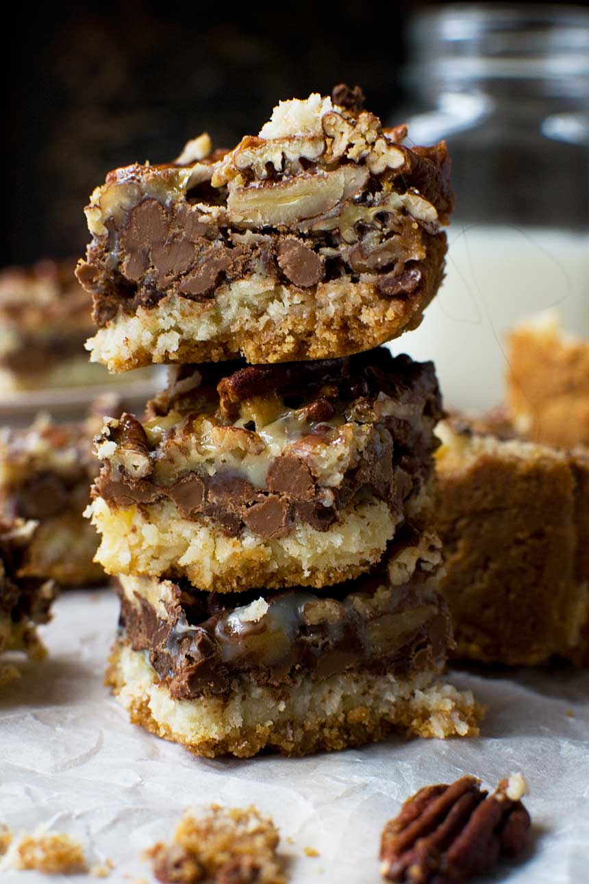 A closeup of a stack of 3 no bowl chocolate pecan bars