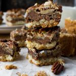 A stack of no bowl chocolate pecan bars with others around them