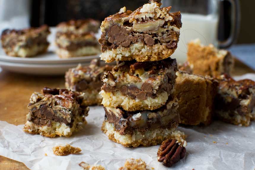 A stack of no bowl chocolate pecan bars with others around them