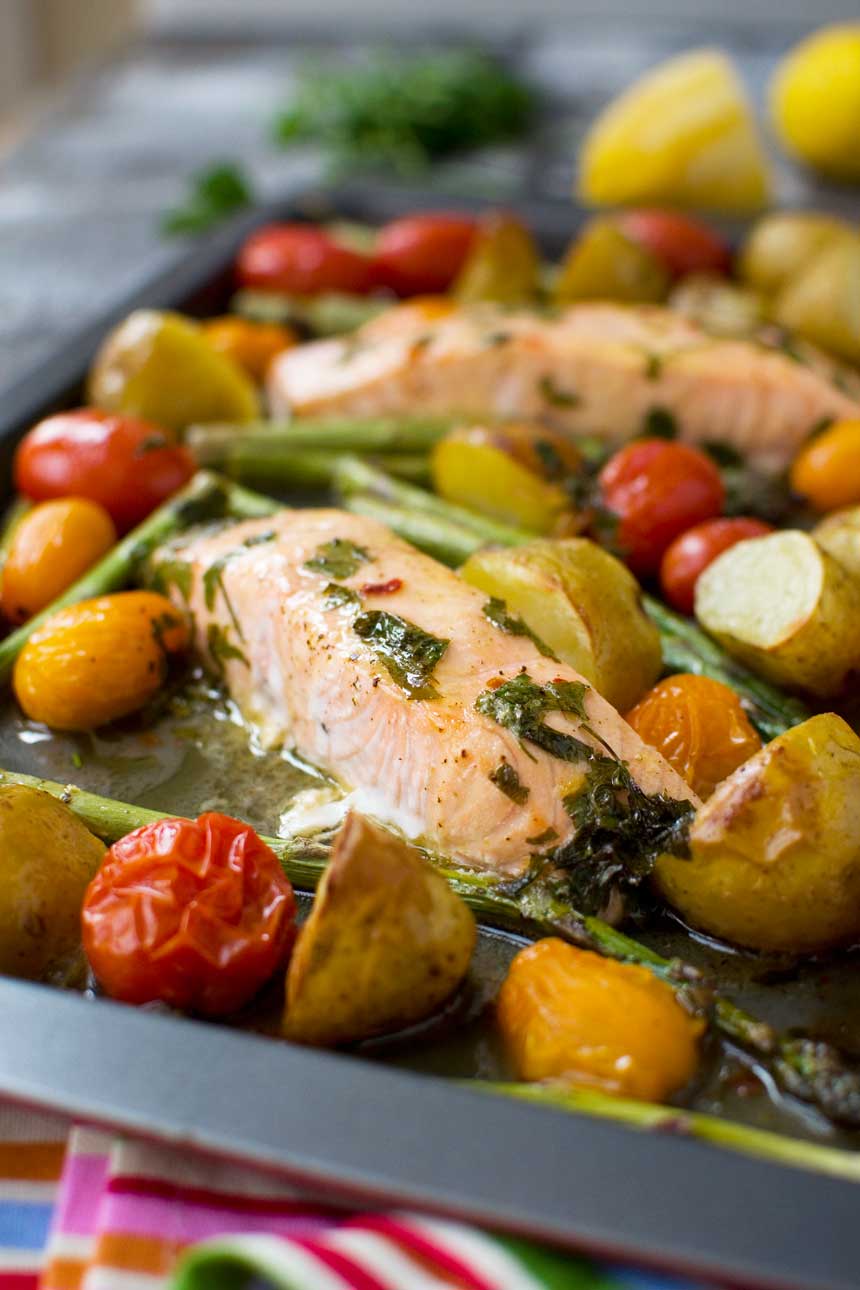 Lemon butter sheet pan salmon with asparagus and potatoes closeup on a baking tray