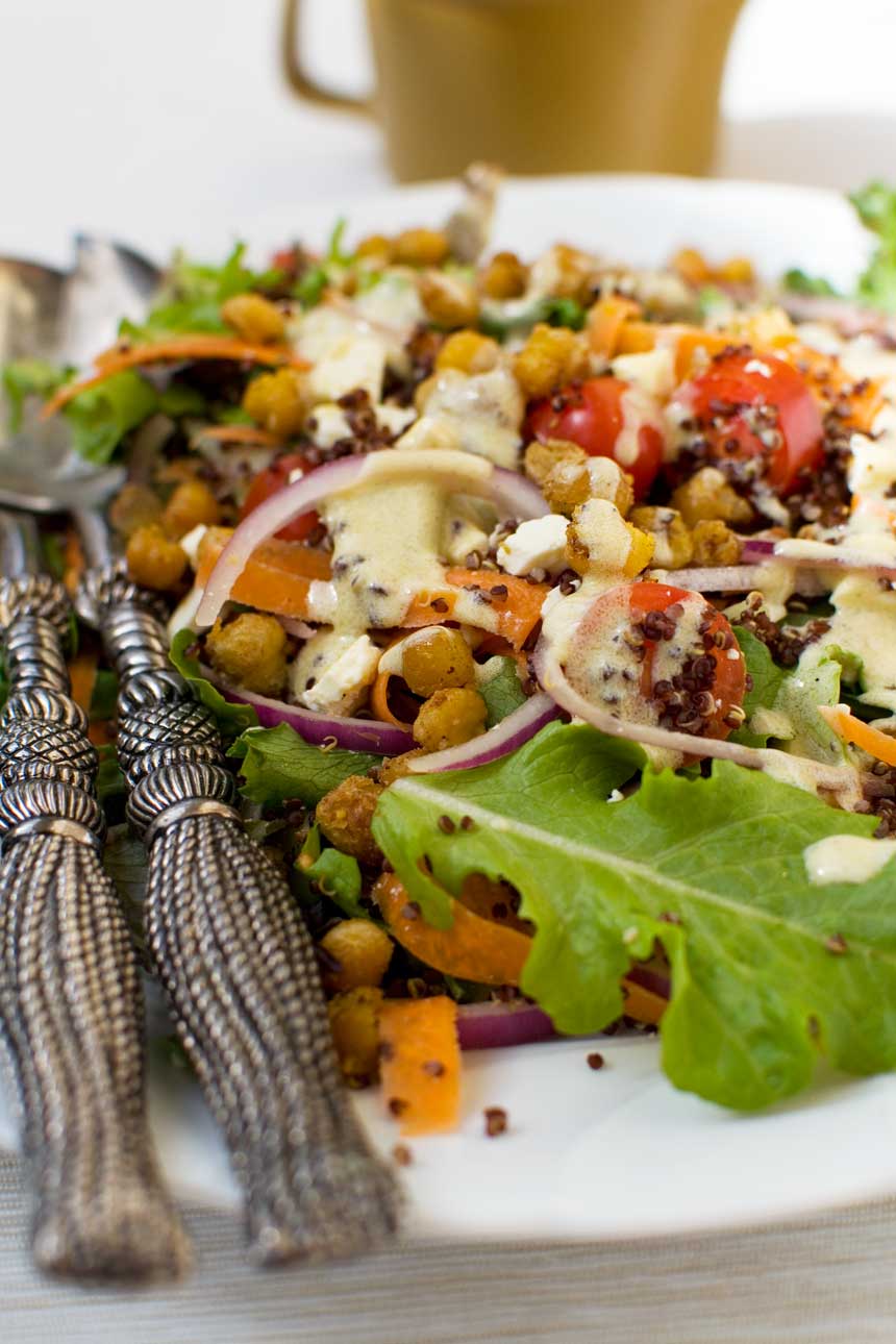 Closeup of Quinoa salad with crispy chickpeas and decorative salad servers.