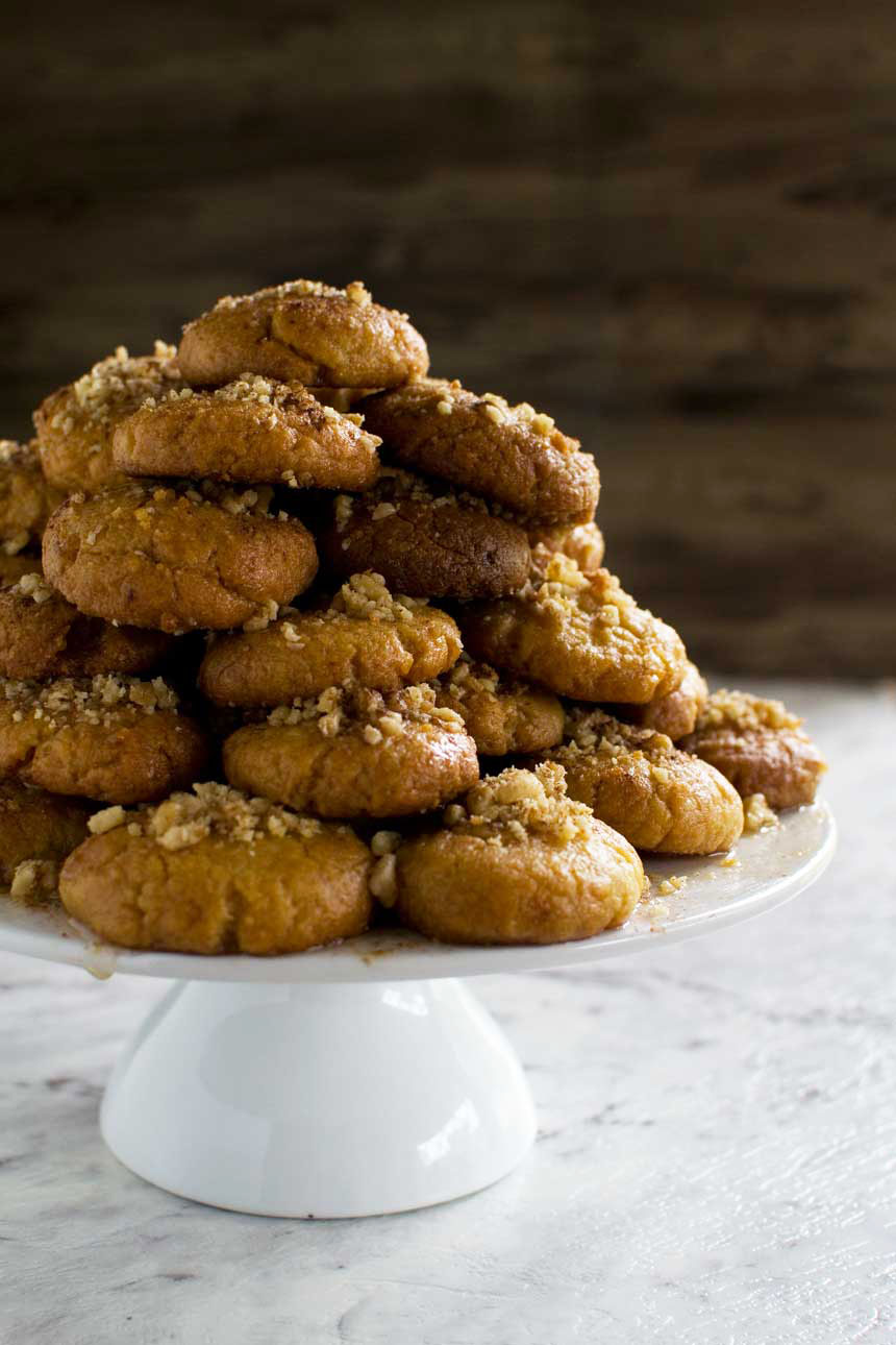 A pyramid of Greek Christmas honey cookies on a white cake stand 