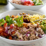 Closeup of tuna salad on a marble background with another salad in the background.