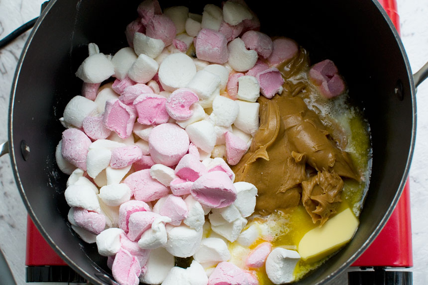 Ingredients for making peanut butter Cheerio bars in a pan from above