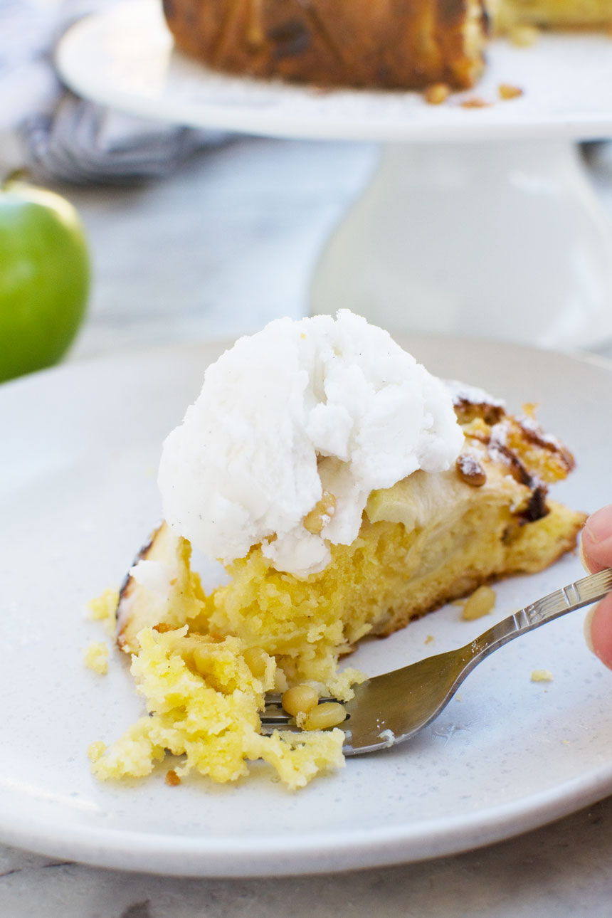 someone eating a piece of easy apple cake (torta di mele) with a fork on a white plate