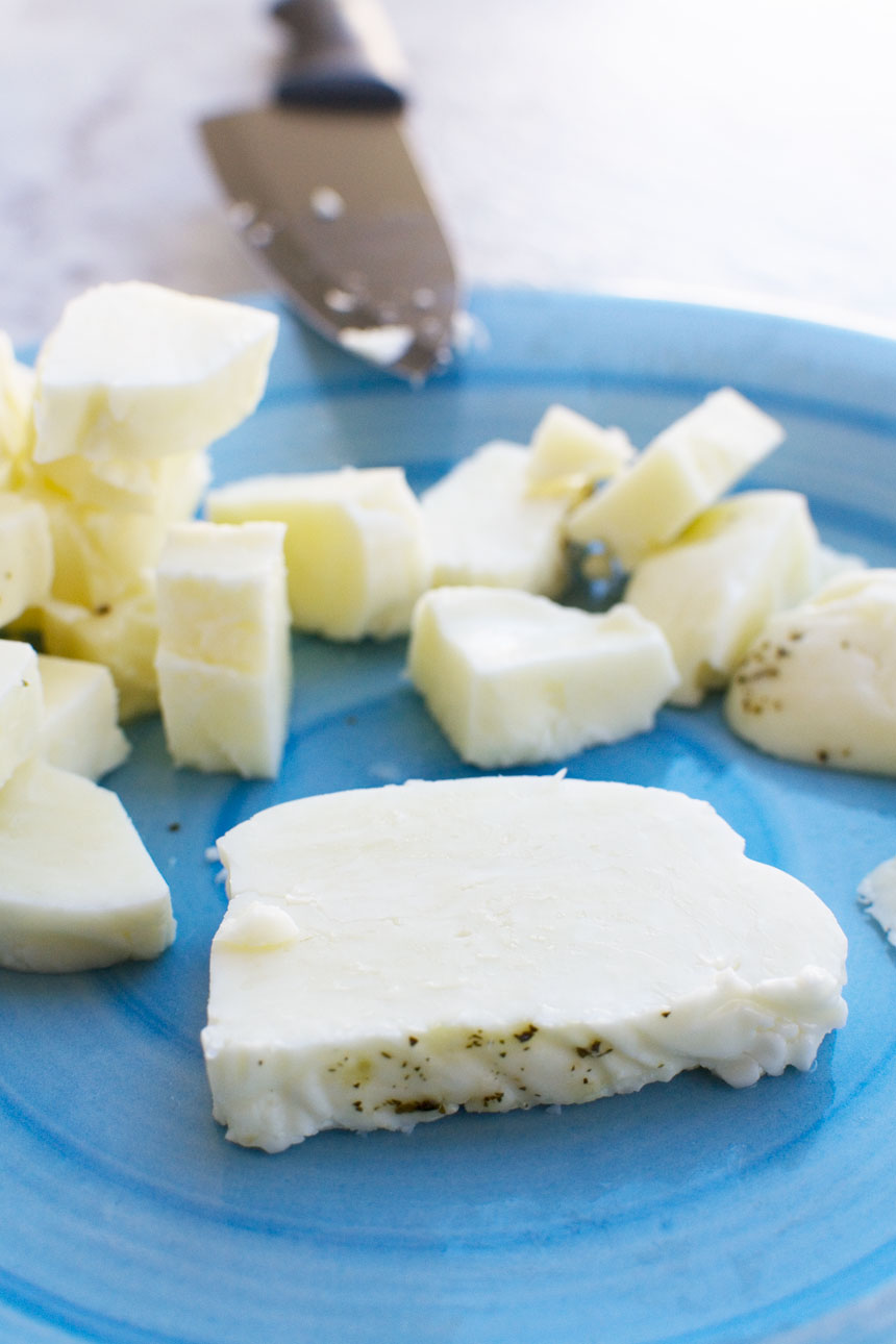 raw halloumi on a blue plate ready to be cooked